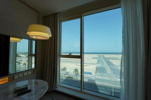 a room with a large window with a view of an airport at Hills HOTEL - فندق هيلز in Al Khobar