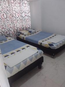 two twin beds in a room withthritisthritisthritisthritisthritisthritisbestosbestosbestos at Hostal Sur Tosc in Cali