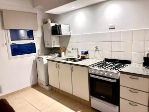 a small kitchen with a stove and a sink at Urbano Alem in Coronel Suárez