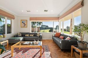 a living room with a couch and a table at Wingana Homestead - Scenic Views, Bundanoon in Bundanoon