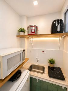 a small kitchen with a sink and a microwave at Studio no Centro com Wi-Fi in Manaus