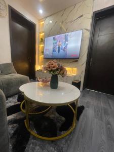 a living room with a table and a tv at Luxury home in Lagos