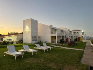 a group of chairs sitting in the grass in front of a building at Apartamentos Alborada in La Paloma