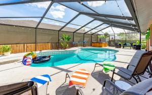 a swimming pool with a glass roof with chairs and a patio at The Pelican/Pool/HotTub/GameRoom in Brandon