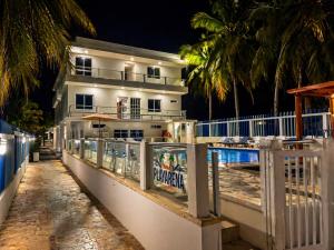 a house on the beach at night with a fence at Hotel Playarena in Coveñas