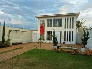 a white house with a red sign on it at Recanto Luigi in Brotas