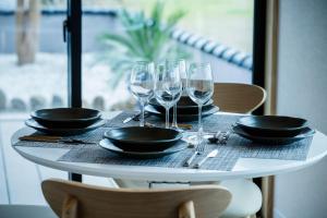 a table with wine glasses and plates on it at LadolcevitA - 総檜サウナ - Private Hinoki Sauna Inn in Mitsugoe +59 photos