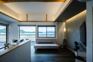 a living room with a couch and a large window at LadolcevitA - 総檜サウナ - Private Hinoki Sauna Inn in Mitsugoe