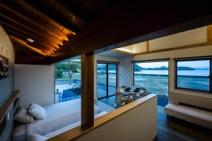 a room with a bed and a view of the water at LadolcevitA - 総檜サウナ - Private Hinoki Sauna Inn in Mitsugoe