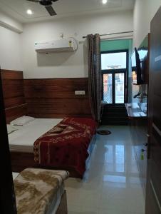 a bedroom with two beds and a tv in it at Well come hotel in Baori Thikria +1 photo