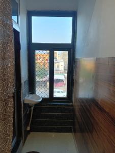 a bathroom with a window and a toilet at Well come hotel in Baori Thikria