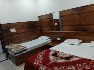 a bedroom with two beds and a mirror at Well come hotel in Baori Thikria