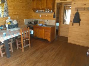 a kitchen with wooden floors and a table and a counter at Rincón Entrerriano in Concepción del Uruguay
