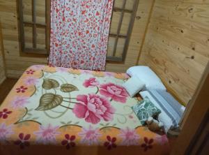 a bed in a room with a floral bedspread at Rincón Entrerriano in Concepción del Uruguay