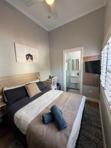 a bedroom with a large bed with blue pillows at Carnarvon Lodge Kirribilli, Sydney in Sydney
