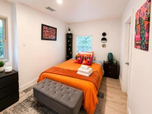 a bedroom with a bed with an orange bedspread at Quiet & Centrally located House - PRIVATE PARKING, LAUNDRY AND STORAGE FOR LUGGAGE in Miami