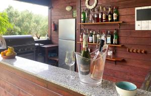 a kitchen with a counter with wine glasses and a refrigerator at Lovely Home In Tarquinia in Tarquinia