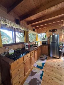 a kitchen with wooden cabinets and a stove in a cabin at Cabaña Facovi in Empalme