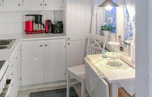 a kitchen with white cabinets and a table and chairs at Amazing Home In Luleå With Sauna in Luleå