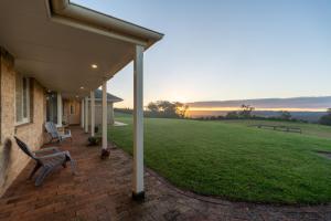 a porch of a house with a bench and a grass field at Wingana Homestead - Scenic Views, Bundanoon in Bundanoon
