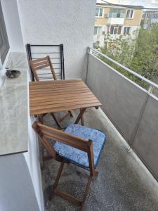 ein Holzstuhl und ein Tisch auf einem Balkon in der Unterkunft La Muzeu in Tîrnăveni