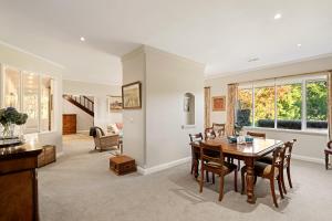 a dining room and living room with a table and chairs at Wingana Homestead - Scenic Views, Bundanoon in Bundanoon +41 photos