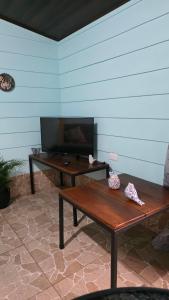 a patio with a wooden bench and a table at Hummingbird Morfus Lodge in Tilarán
