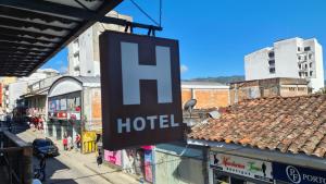 a sign for a hotel hanging from a building at Casa Hotel la Alsacia in Santa Rosa de Cabal
