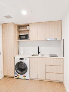 a kitchen with a washing machine and a sink at Auburn Studio, Entire Studio with Ensuite toilet and kitchen in Sydney