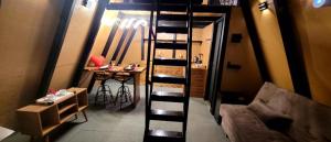 a living room with a spiral staircase leading to a bar at Chalé in Alfredo Wagner