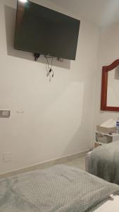 a bedroom with a flat screen tv on the wall at Hostal Rose Moor in Jardin