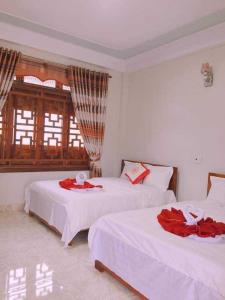 a bedroom with two beds with red flowers on them at An Binh Homestay in Phong Nha