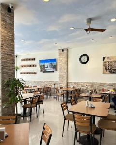 a restaurant with tables and chairs and a clock on the wall at Hotel Plaza in Tuxpan de Rodríguez Cano