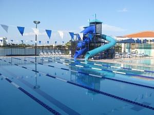 an empty swimming pool with a blue water slide at Coastal Sun Retreat in St. Pete Beach