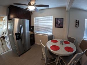 a kitchen and dining room with a table and a refrigerator at Coastal Sun Retreat in St. Pete Beach