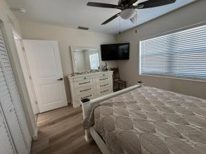 a bedroom with a bed and a ceiling fan at Coastal Sun Retreat in St. Pete Beach +23 photos