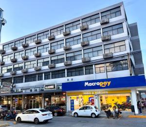 a large building with cars parked in front of it at Hotel Plaza in Tuxpan de Rodríguez Cano