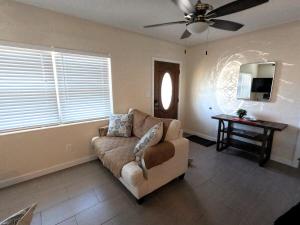 a living room with a couch and a ceiling fan at Coastal Sun Retreat in St. Pete Beach
