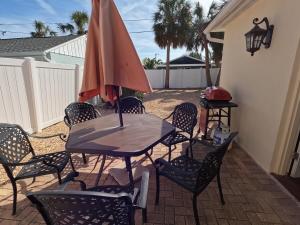 a table and chairs with an umbrella on a patio at Coastal Sun Retreat in St. Pete Beach