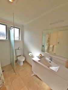 a bathroom with a tub and a toilet and a sink at Golden Aura Suites in Stratford