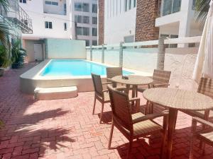 a patio with tables and chairs next to a swimming pool at Scandi Apartment Boracay by Simple Realty Management in Boracay
