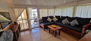 a living room with a black couch and a table at Scandi Apartment Boracay by Simple Realty Management in Boracay