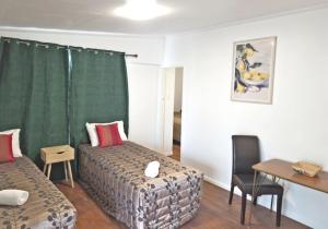 a room with a bed and a table and a table and chairs at Golden Aura Suites in Stratford