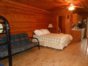 a bedroom with a bed and a couch in a cabin at Bay Landing Camping Resort Deluxe Cabin 29 in Bridgeport