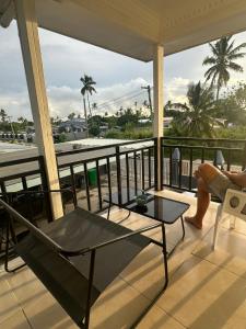 a balcony with a table and a view of the ocean at The KentiGate - much more than a room in Nuku‘alofa