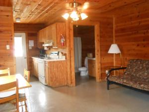 BridgeportにあるBay Landing Camping Resort Cabin 14のリビングルーム(ソファ付)、キャビン内のキッチンが備わります。