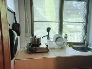 a kitchen counter with a stove and a window at Little house in Koh Samui