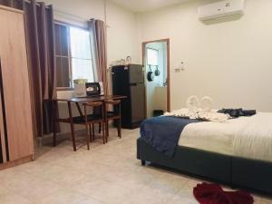 a bedroom with a bed and a desk and a table at Little house in Koh Samui +3 photos