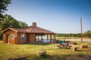 un padiglione in legno con tavolo da picnic e panca da picnic. di Bay Landing Camping Resort Cabin 14 a Bridgeport Altre 8 foto