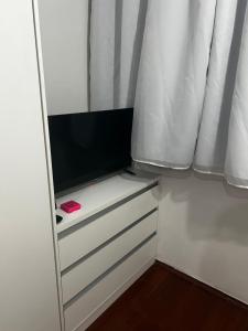 a small cabinet with a television in a room at Ap Aconchego in Campinas
